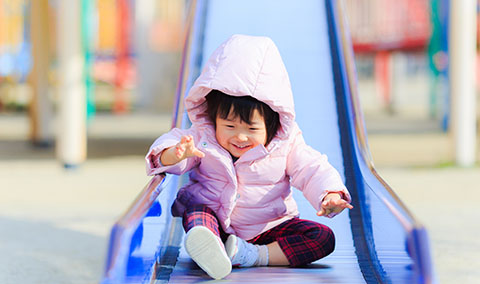 公園の遊具で遊ぶ親子の様子